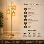A gold three-light floor lamp with cylindrical glass shades is shown in a room setting with dimension labels and a specifications panel. The image includes text listing height, base diameter, material, bulb type, voltage, weight, and feature highlights.
