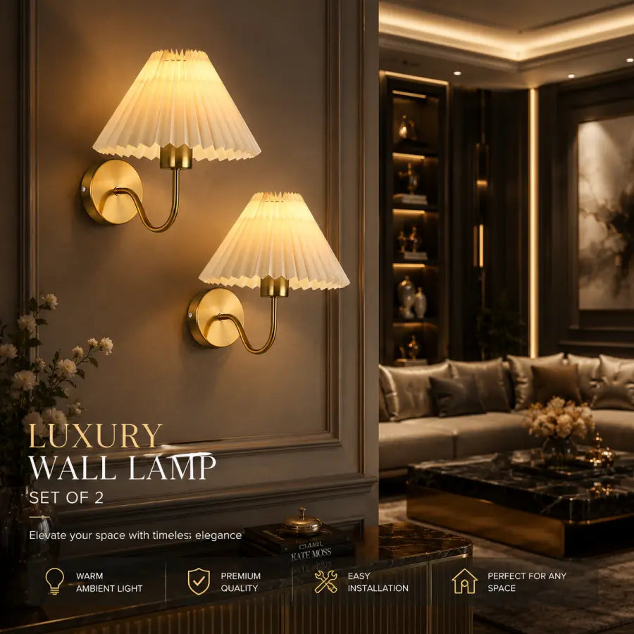 Two luxury wall sconces with pleated cream shades and gold metal bases mounted on a dark wall in an elegant living room setting. Text overlays at the bottom read 'LUXURY WALL LAMP SET OF 2'.