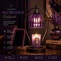 A purple ribbed glass candle holder lamp with a glowing candle inside, set on a dark wooden table in a dimly lit room. The background features a matching purple glass vase with dried lavender and a book with 'CHANEL' and 'VOGUE' on the cover.