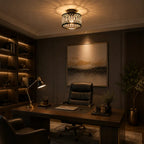 A modern black metal semi-flush mount ceiling light with a decorative filigree shade, glowing warmly in a dark, elegant home office setting.