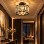 A modern semi-flush mount ceiling light fixture with a dark metal geometric frame and clear hanging prisms, glowing warmly in a luxurious hallway.