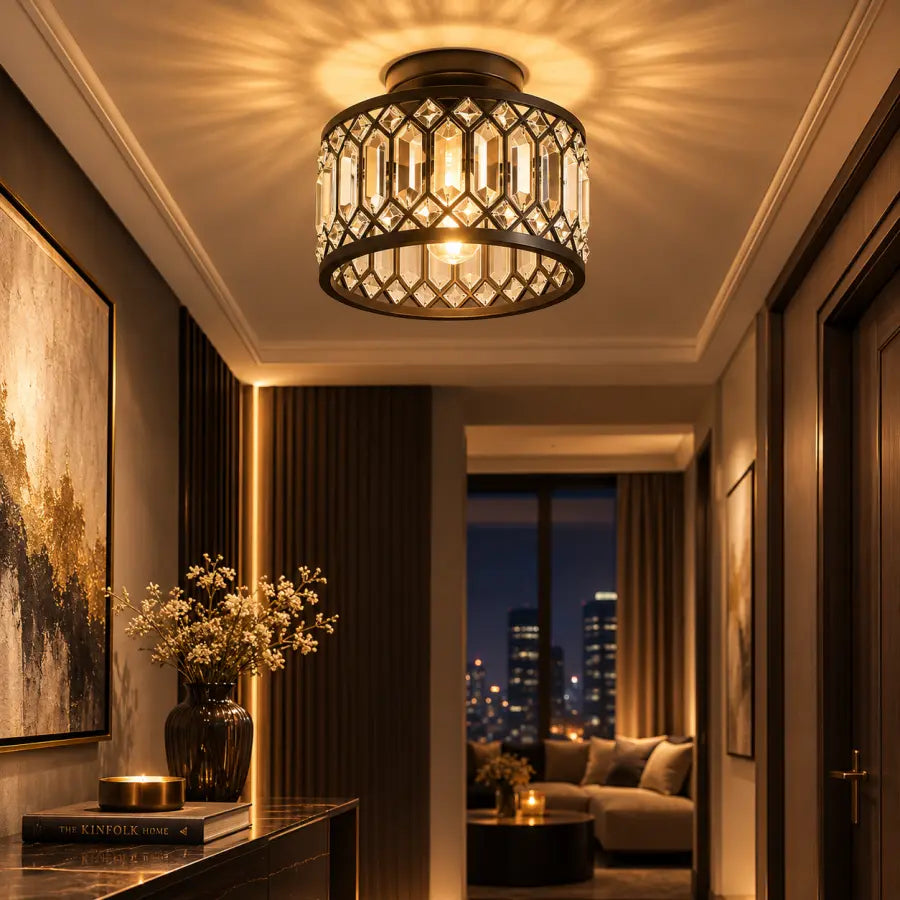 A modern semi-flush mount ceiling light fixture with a dark metal geometric frame and clear hanging prisms, glowing warmly in a luxurious hallway.