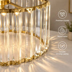 A close-up of a modern cylindrical table lamp with a gold metal frame and clear vertical crystal prisms, glowing with warm light on a tabletop. Three white text callouts on the right read 'Premium Crystal,' 'Metal Frame,' and 'Durable & Long Lasting.